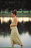 pregnant woman walking by a lake