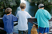 boys fishing from a bridge
