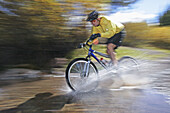 Man splashing through water on a mt. biking in Sun Valley, Idaho. USA