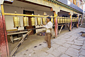 a tibetan pilgrim perform the internal kora in the temple of the triad of manjushri vajrapani and avaloketesvara. lhasa. tibet. china. asia.