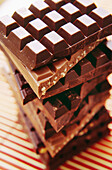 Tall stack of chocolate bars on colour pelted straw matt