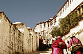 Two elderly women climbing to the top of the Potala palace in Lhasa, Tibet, China, Asia.