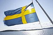 Swedisch flag and sea, summer day in the coast area. Ulvön. Ångermanland. North east Sweden