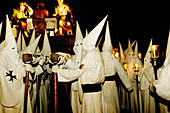 Penitents next to the Holy Supper float. Easter. Cuenca. Spain.