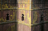 Ornate windows carved in yellow lichen-covered red rock walls of bizarre cross-shaped Beta Georgis (Church of St. George), Lalibela, Ethiopia.