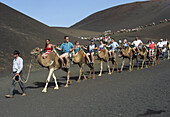 Tourists on camels. Timanfaya National Park. Lanzarote. Canary Islands. Spain