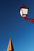 Church spire and street lamp. Lembach, Alsace. France.