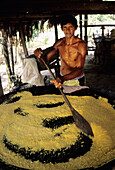 Tribes man stires corn meal for village people in the Amazon Rain Forest of Brazil.