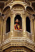 Man in window of traditional mansion, Jaisalmer. Rajasthan, India