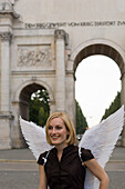 Engel, junge Frau mit Engelsflügeln beim Siegestor, München, Bayern, Deutschland