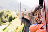 Zwei junge Frauen schauen aus einem Fenster von einem fahrenem Zug