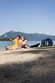 Two young women, girls, having a picnic on the lake shore, Lake Walchensee, Upper Bavaria, Bavaria, Germany