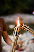 Person lighting a torch, River Isar, Munich, Bavaria, Germany