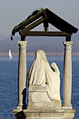 A statue of the Madonna seems to look for the safety of the sailors in the Lake Maggiore. Arona, Novara, Italy