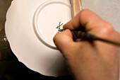 Porzellanteller wird signiert, Porzellan Manufaktur Meissen, Sachsen, Deutschland