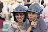Two Japanese girls with traditional Bavarian costume at Oktoberfest. Munich, Bavaria, Germany