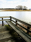 A lovely river scene in Upstate New York featuring a weathered wooden deck and the Mohawk River. USA.