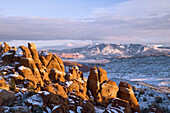 The La Sal mountains and the fins of the Fiery Furnace awash in sunset color, Arches National Park, Utah, USA.
