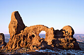Turret Arch awash in warm early morning light on a crisp winter morning, Arches National Park, Utah, USA.