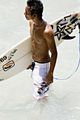 surfer holding surfboard in the water