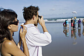 couple holidaying and taking snapshot on beach