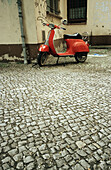 Bike, Bikes, Cobble, Cobbles, Coblestone, Coblestones, Color, Colour, Cycle, Cycles, Daytime, Deserted, Exterior, Moped, Mopeds, Motorbike, Motorbikes, Motorcycle, Motorcycles, One, Outdoor, Outdoors, Outside, Parked, Paving stone, Red, Street, Streets, T