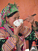 Flower Hmong woman eating in market. Bac Ha, Northern Vietnam (april, 2006)