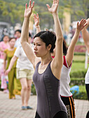 A woman does aerobics in the park. Hanoi, Vietnam (april 2006)