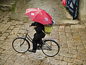 riding cobbled streets in the rain, Lijiang, China