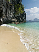 bathing in the emerald sea, swimmer off an island in the Bacuit Archipelago, Palawan, Philippines