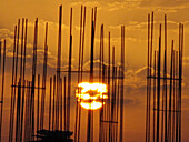 Sunrise behind the steel bar structure of a building construction work. Pune, Maharashtra, India.