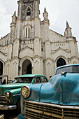 Iglesia del Santo Angel Custodio (Church of the Holy Guardian Angel). Old cars parked in front. Havana. Cuba.