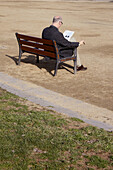 Man reading on a bench.