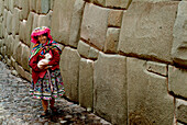 Inca woman with lamb at Inca wall, Cusco, Peru, South America