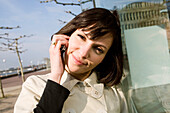 Young woman with mobile phone at a promenade, Duesseldorf, North Rhine-Westphalia, Germany