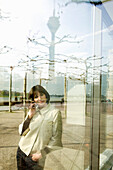 Young woman with mobile phone at a promenade, Duesseldorf, North Rhine-Westphalia, Germany