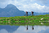 zwei Mountainbiker vor dem Wendelstein, See mit Spiegelung, Wendelsteinregion, Bayerische Voralpen, Bayerische Alpen, Oberbayern, Bayern, Deutschland