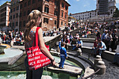 Young woman with a red Roma bag at Fontana della Barcaccia on Piazza di Spagna, Spanish Steps in background, Rome, Italy