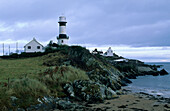 Leuchtturm und Häuser am Dunagree Point unter Wolkenhimmel, Halbinsel Inishowen, County Donegal, Irland, Europa