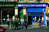 Menschen stehen an einer Bushaltestelle, Cobh, County Cork, Irland, Europa