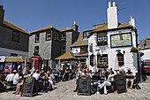 People sitting in front of the Sloop Inn, St. Ives, Cornwall, England, United Kingdom
