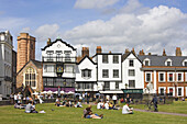 Leute sitzen im Gras an der Cathedral Close, Exeter, Devon, England, Großbritannien