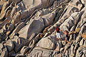 Italy Sardinia Capo Testa bizarre rock landscape couple climbing