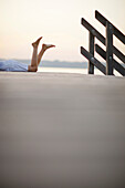 Woman lying on jetty at lake Starnberg, Ambach, Bavaria, Germany