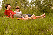 Teenage couple lying in meadow, Freising, Bavaria, Germany