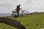 A Massai with bicycle and dog in Masai Mara, nature reserve and wild life reseve, Kenia, Africa