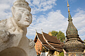 Buddhistic statue of stone in front of the Sim of Vat Xieng Thong at Luang Prabang, Laos