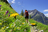 Female hiker on the way to alpine lodge Memminger hut, Lechtal range, Tyrol, Austria