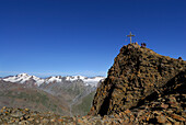group of hikers on summit of Kreuzspitze, Weißkugel in background, Ötztal range, Tyrol, Austria