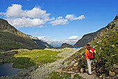 young woman at notch Untere Seescharte with view to lake Kreuzsee, Wangenitzsee and hut Wangenitzseehuette, Schobergruppe range, Hohe Tauern range, National Park Hohe Tauern, Carinthia, Austria